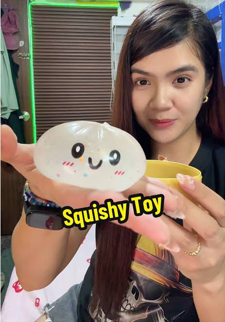Hand gently wiping a squishy toy clean with a damp soft cloth
